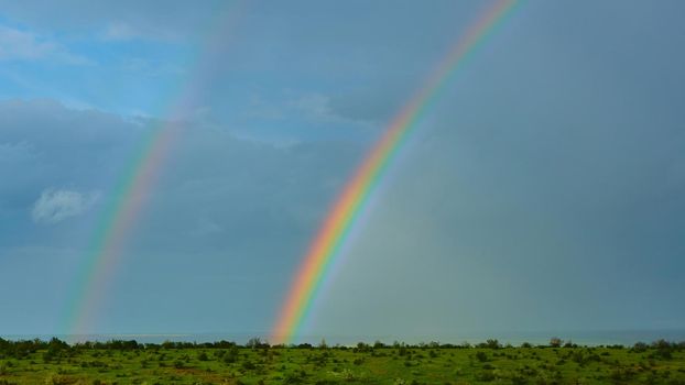 Rainbow over a field after thunderstorm.