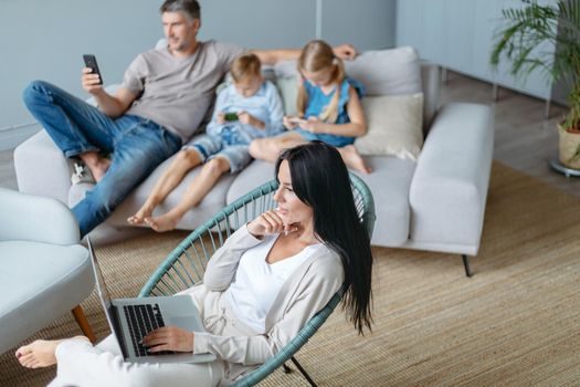 family with their devices spends the evening in a cozy living room . concept of family pastime.