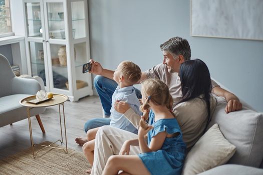 happy man and his family taking a selfie in their apartment. close-up.