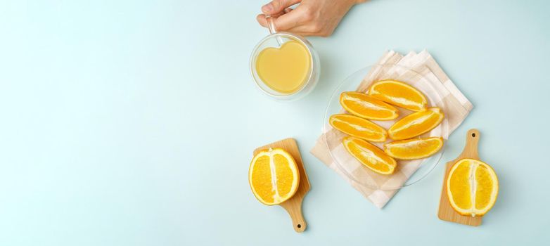 Orange juice in the glass. Healthy drink on a blue background. View from above. Love for fruits, healthy food. Copy space