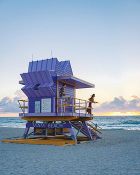 Miami Beach, a couple on the beach at Miami Florida, lifeguard hut Miami Asian women and caucasian men on the beach during sunset