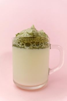 Dalgona Matcha Latte, pink background. Matcha green tea. Trendy drink. Superfoods. Dairy beverage. Korean drink
