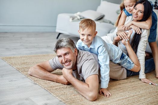 happy family with kids having fun in their living room. photo with a copy-space.