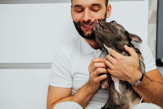 Adult Caucasian Man Hugging His Lovely Pet, Small French Bulldog Licks Its Owner