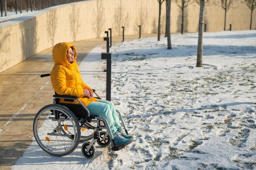 Woman in wheelchair relaxing in winter park