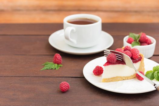 Raspberry pie (cheesecake) made from fresh raspberries with tea on a wooden background.Copy space