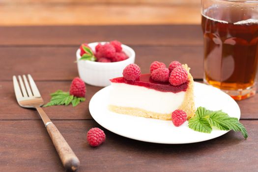 Raspberry pie ,cheesecake made from fresh raspberries with tea on a wooden background.