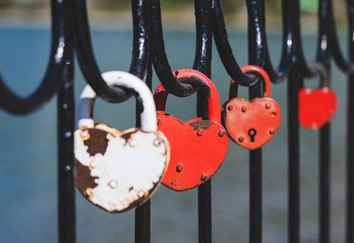 A red love lock attached to the railing of the bridge.