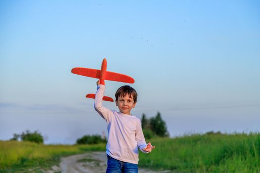 A boy plays in an airplane in nature in the summer . The boy dreams of the future. Buying real estate advertising. An article about choosing a profession. A happy child. Children's toys .