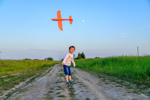 A boy plays in an airplane in nature in the summer . The boy dreams of the future. Buying real estate advertising. An article about choosing a profession. A happy child. Children's toys .