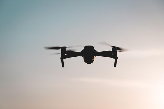 The drone is in flight at sunset . Video shooting from above. An article about the choice of a quadrocopter. Pros and cons of the drone. Sunset
