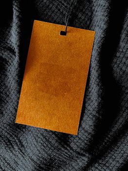 Blank fashion label tag, sale price card on luxury fabric background, shopping and retail concept