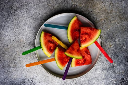 Fresh and tasty summer dessert with organic watermelon slices made in popsicle on the plate