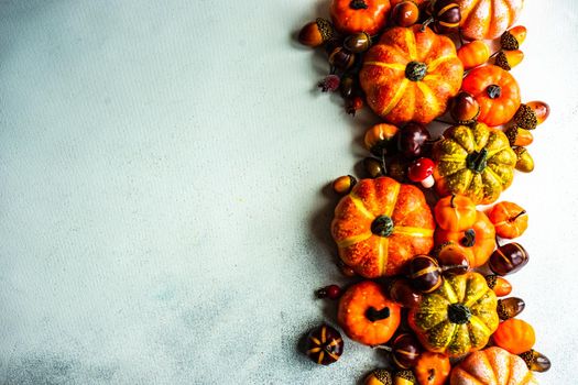 Autumnal frame concept with pumpkins on concrete background