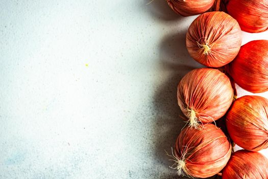 Red dry onion vegetables  as a autumnal harvest concept on concrete background