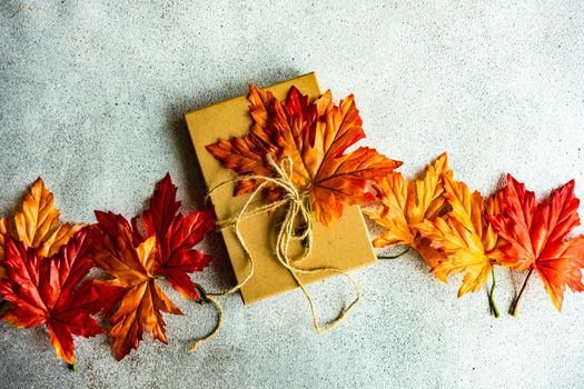 Autumnal gift box wrapping concept for Thanksgiving holiday on the concrete background