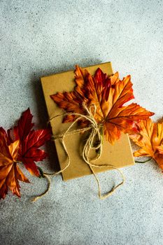 Autumnal gift box wrapping concept for Thanksgiving holiday on the concrete background