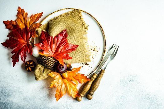 Autumnal place setting for Thanksgiving holiday dinner on concrete background