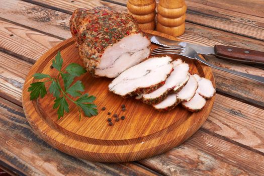 Baked meat on cutting board on wooden surface