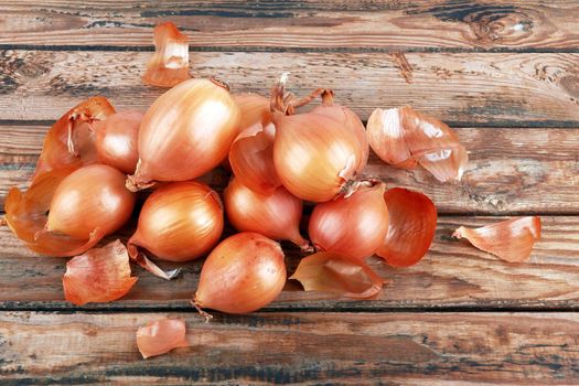 Ripe fresh golden onions on a wooden background