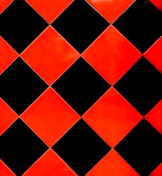 Red and black mosaic ceramic tile abstract pattern interior surface floor texture background.