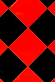 Red and black mosaic ceramic tile abstract pattern interior surface floor texture background.