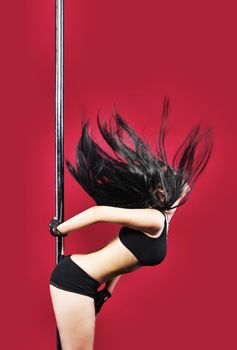 Woman in lingerie pole dance with black hair on red