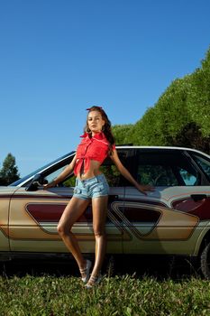 Sexy young girl near retro graffiti retro car at summer sunset