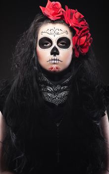 Serious woman in day of the skull mask