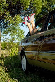 Beauty sexy woman legs out from old style car