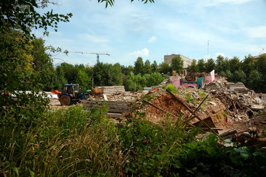 tractor clear construction site from garbage at summer day