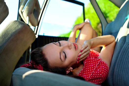 Young attractive woman lay in car - looc at camera