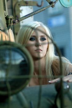 Pretty young girl stand near old rusty truck at summer evening