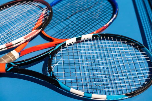 broken tennis rackets blue tennis court.