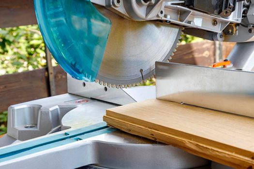 Miter saw in the process of sawing off a wooden part.