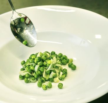 Green peas in the kitchen in a pan. Preparing a side dish for dinner.