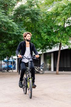 stylish young man riding his bike through the city, urban lifestyle and sustainable mobility concept, copy space for text