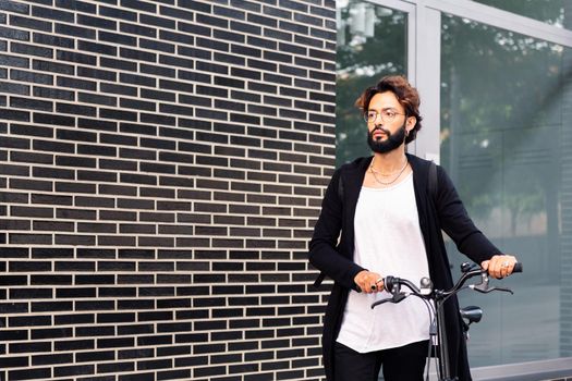 young caucasian man walking with his bike, concept of urban lifestyle and sustainable mobility, copy space for text