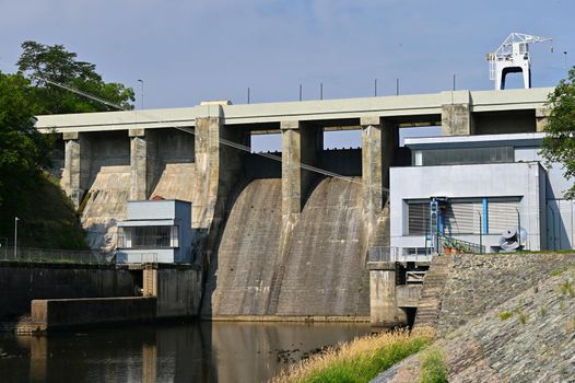 A dam on the Brno Reservoir by the Svratka River with a small power plant. Beautiful sunny summer day in nature.