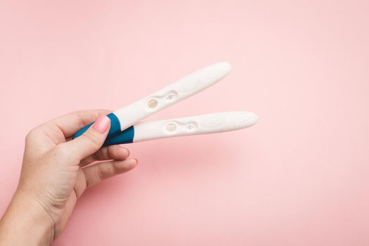 Pregnancy test in hand on a pink background . Positive test. Pregnancy copy space. Motherhood