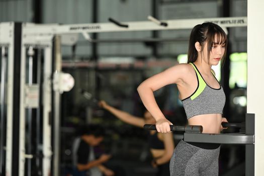 Fitness woman exercising with exercise machine in gym. Healthy lifestyle concept.