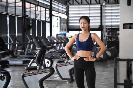 Beautiful fitness woman in sportswear standing in the gym.