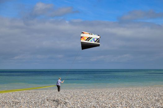 A man controls a kite on the coast of the Atlantic Ocean