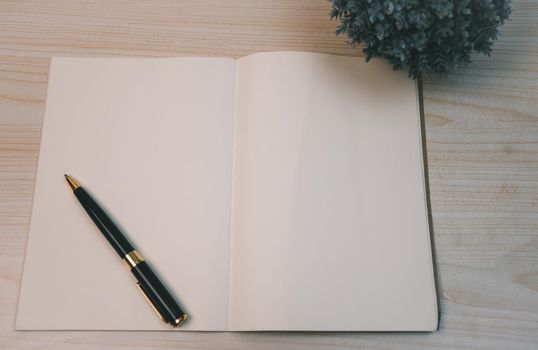 Notebooks and diary pen and planner top view wood background.