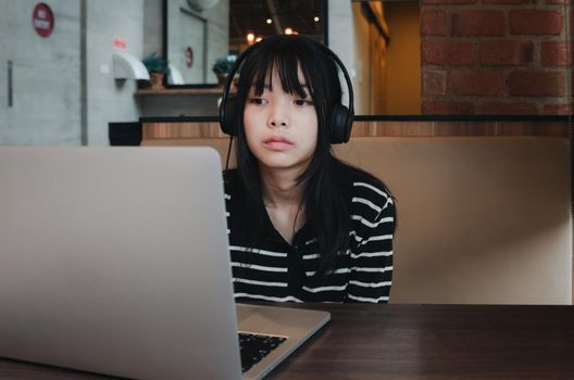 girl using computer laptop watching movie or listen music with earphone and digital internet communication social network.