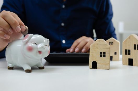 Man holding a piggy bank save money to invest or buy real estate. Business finance insurance and investment management payment concept.