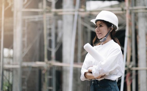 Female construction engineer. Architect with a tablet computer at a construction site. Young Woman looking, building site place on background. Construction concept.