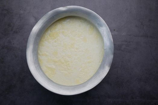 top view of full cream milk in a silver container on black background ,