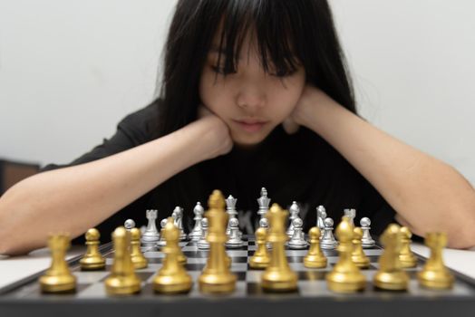cute young girl playing chess using her mind.