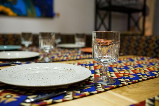 Served table with plates,glasses and cutlery in a cafe for receiving guests